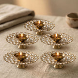 Gold-colored brass decorative diya lamps with acrylic glass floral design and clear crystal embellishments for Diwali puja