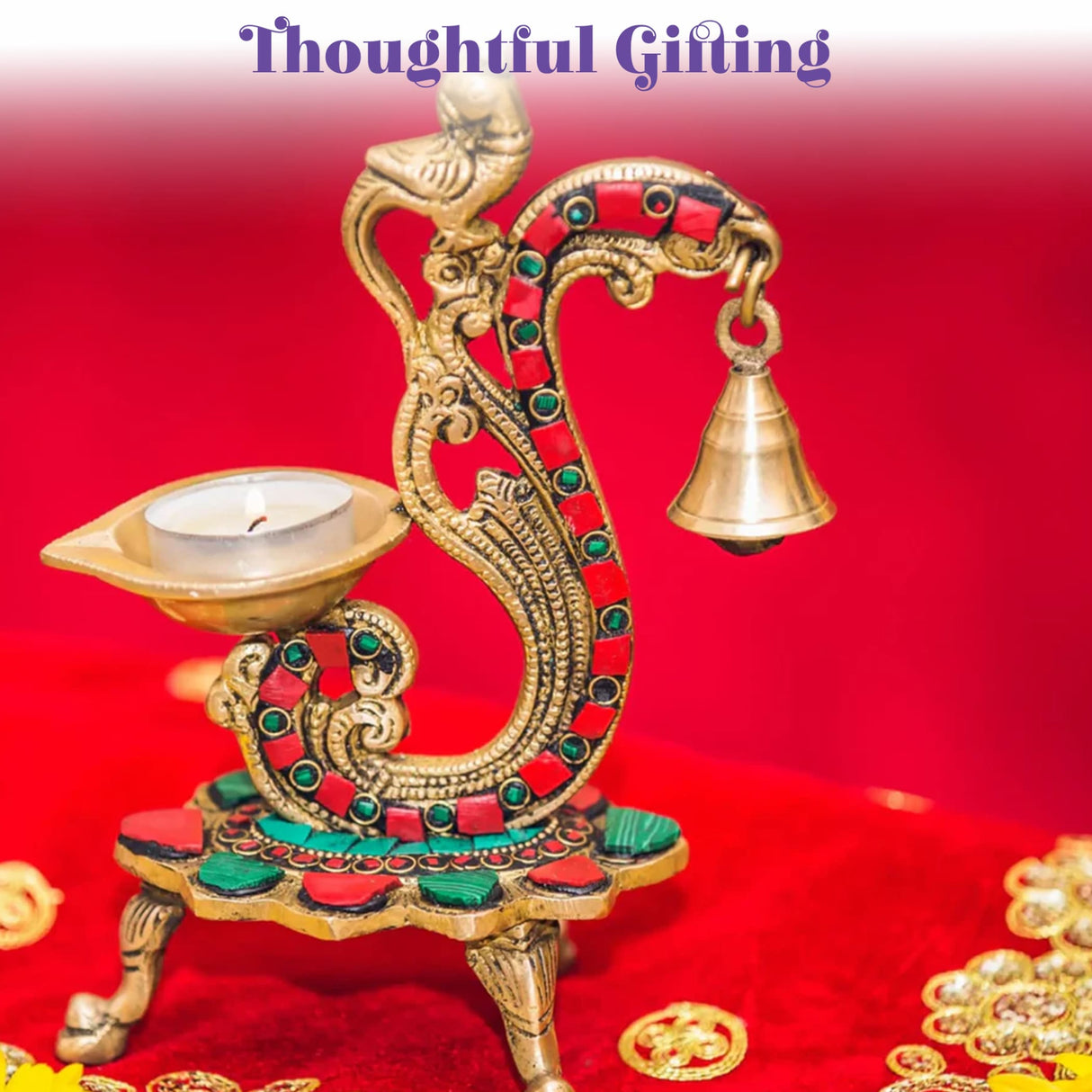 Golden brass serpent-shaped oil lamp diya with red and green inlaid stones and hanging bell for diwali decoration