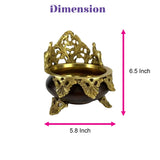 Golden brass urli bowl with intricate elephant and floral designs on dark brown ceramic base for pooja decor