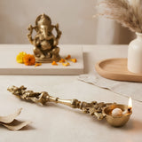 Golden brass decorative oil lamp with intricate carvings and lit flame for indian cultural religious decor and diwali gift