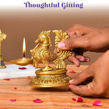 Golden brass peacock diya oil lamp with intricate feather detailing on an ornate base for temple and home decor