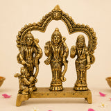 Golden brass figurine depicting hindu deities vishnu shiva and devi under ornate arch with sun motif, ideal for pooja decor