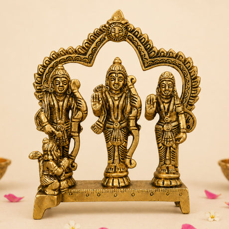 Golden brass figurine depicting hindu deities vishnu shiva and devi under ornate arch with sun motif, ideal for pooja decor