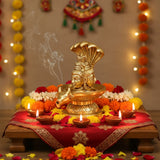 Golden elephant-shaped incense burner with intricate details and red cloth base for Shiva Pooja