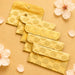Set of five golden-yellow brocade fabric money envelopes with embroidered paisley pattern and metallic circular clasps