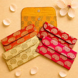 Brocade fabric money envelopes with vibrant orange red and gold paisley pattern and metallic button closures for indian gifts