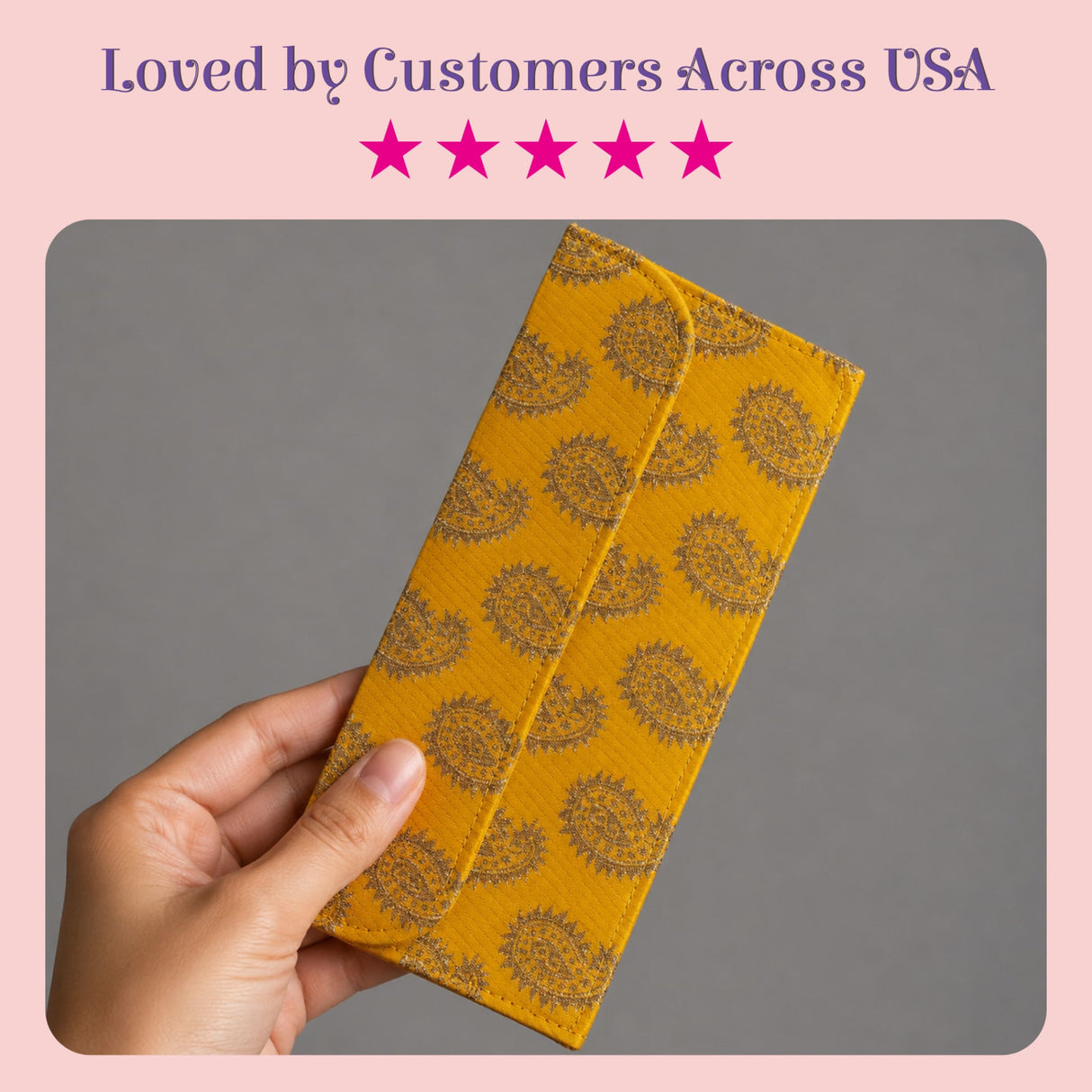 A mustard-yellow brocade fabric wallet with dark brown paisley pattern and flap closure for Indian wedding cash gifts
