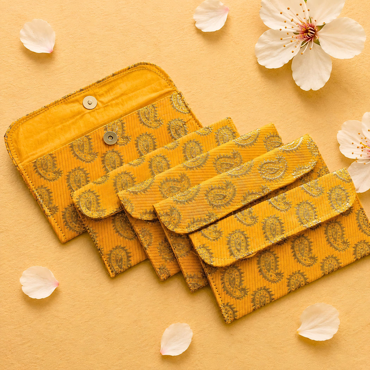 Vibrant yellow brocade fabric money envelopes with paisley pattern and metallic button closures for indian weddings and gifts