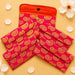 Vibrant pink and gold brocade fabric paisley quilted clutch with orange interior and black button closure for Indian weddings