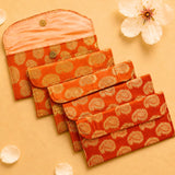 Set of five orange quilted brocade fabric money envelopes with gold paisley patterns and brass button closures
