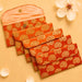 Set of five orange quilted brocade fabric money envelopes with gold paisley patterns and brass button closures