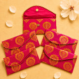 Brocade fabric money envelopes in vibrant fuchsia with gold paisley pattern and decorative button closures for gifting