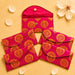 Brocade fabric money envelopes in vibrant fuchsia with gold paisley pattern and decorative button closures for gifting