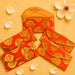 Vibrant orange brocade fabric money envelopes with intricate gold paisley patterns and decorative golden trim for cash gifts