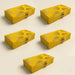 Bright yellow brocade gift boxes with gold leaf floral patterns and ornate clasps for indian wedding favors