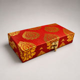 Red rectangular brocade gift box with gold paisley pattern and golden clasp for indian wedding favors