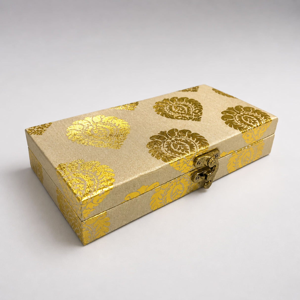 A rectangular gold-patterned brocade fabric gift box with a metallic clasp for indian wedding favors