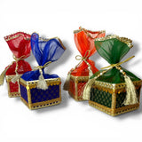 Colorful brocade potli gift boxes with gold-trimmed organza tops and tassels for traditional indian wedding favors