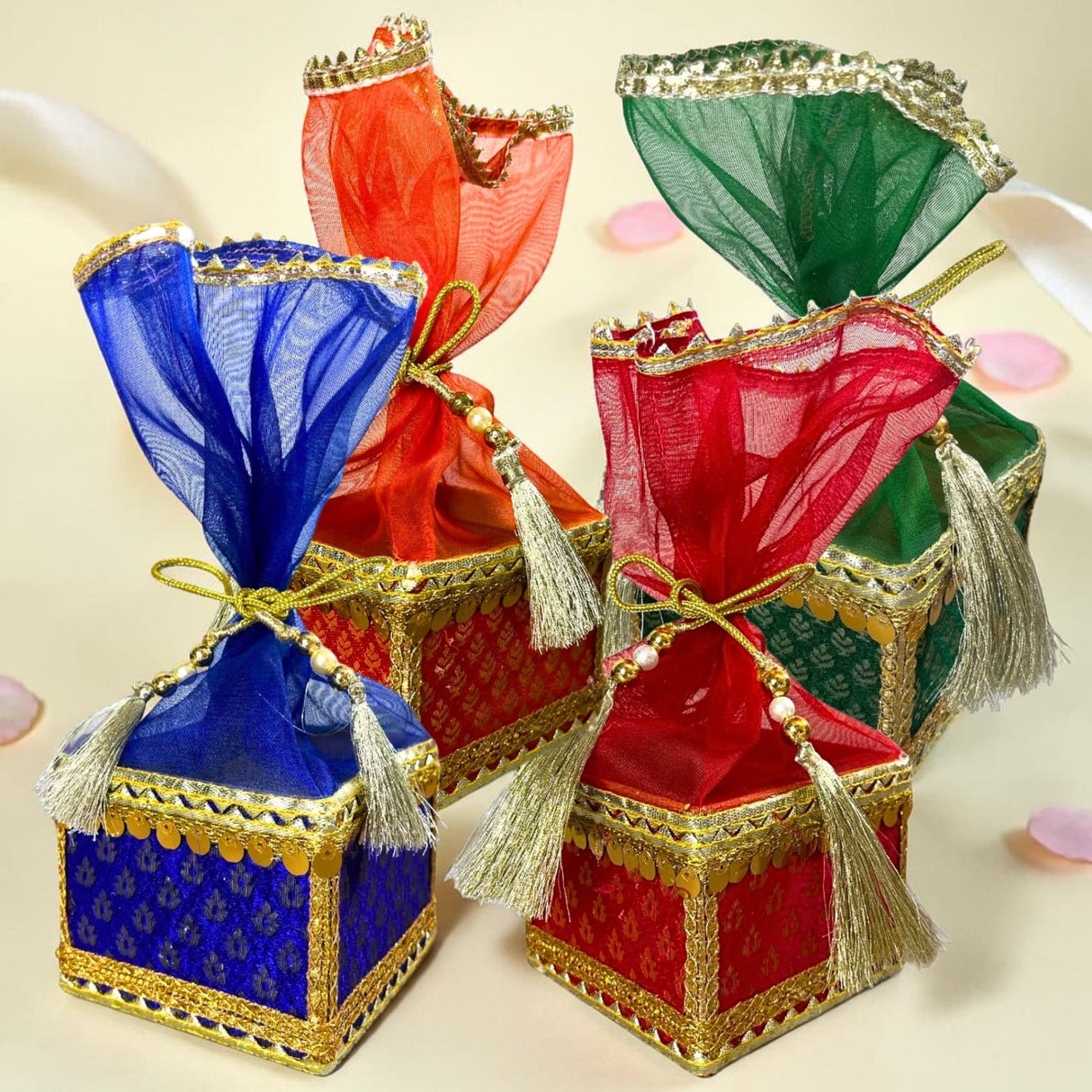 Colorful ornate brocade potli gift boxes with sheer organza tops and gold-trimmed edges for traditional indian wedding favors