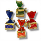 Colorful brocade potli gift boxes with gold-trimmed organza tops and tassels for traditional indian wedding favors