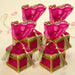 Fuchsia sheer organza brocade potli gift boxes with gold-trimmed edges and tassels for traditional Indian weddings