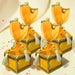 Brocade potli gift boxes in gold with orange organza drawstrings and silver tassels for traditional wedding favors