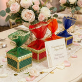 Brocade potli gift boxes in green red and blue with gold trim and sheer organza bows for traditional indian wedding favors