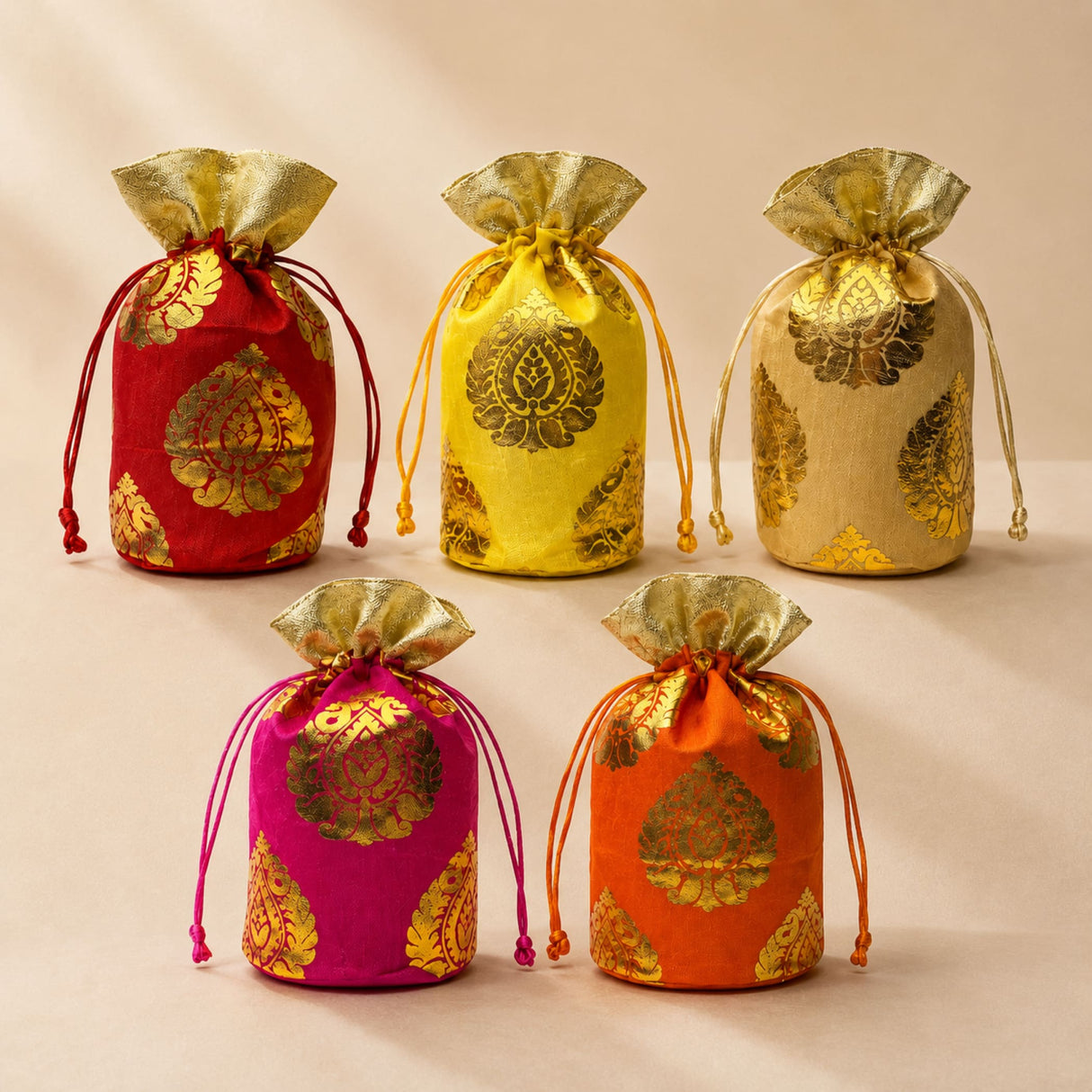 Traditional Indian brocade print silk potli bags in vibrant red yellow gold pink and orange with golden paisley patterns