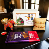A vibrant red and gold handmade elephant-shaped candle holder with intricate gold detailing in designer rakhi gift hamper