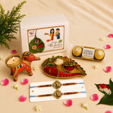 Designer rakhi gift hamper for brother and bhabhi with gold and red handmade bracelets chocolates and elephant candle holder