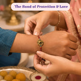 Gold-toned designer rakhi with intricate design and red beaded string for brother and bhabhi gift hamper