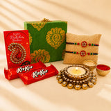 Gold ornate diya with lit candle and crystal embellishments in designer rakhi gift hamper for brother and bhabhi