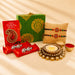 Gold ornate diya with lit candle and crystal embellishments in designer rakhi gift hamper for brother and bhabhi