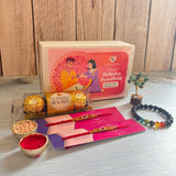 Designer rakhi gift hamper with pink and purple lovespire gift box featuring an illustration of two people exchanging gifts