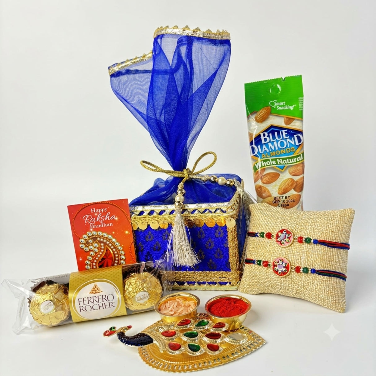 Designer rakhi gift hamper set featuring a blue and gold embroidered gift box with sheer blue organza cover and golden ribbon