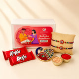 Gold-colored peacock-shaped decorative tray with red and green enamel and rhinestones in designer rakhi gift hamper set
