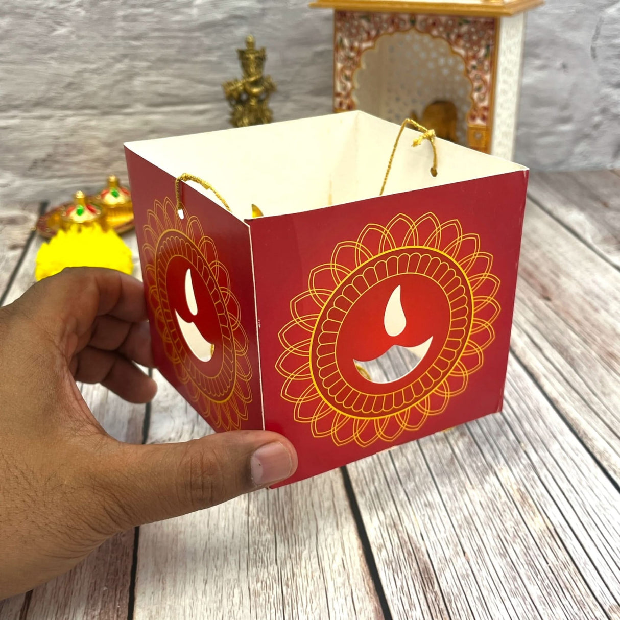 Red paper lantern with gold mandala and diya cutout design for Diwali decoration