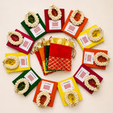 Colorful velvet drawstring pouches with gold lattice detailing holding white pearl garlands in varalakshmi vratham gift hamper