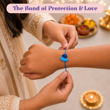 A vibrant blue plastic boat-shaped cartoon rakhi with matching string worn on an arm for raksha bandhan gift