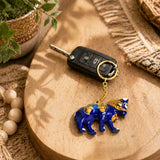 Handmade ceramic blue elephant keychain with gold accents attached to car key fob as an Indian good luck charm