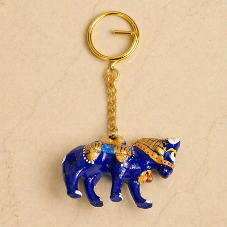 Handmade ceramic blue elephant keychain with gold accents attached to a golden ring for bags and gifts