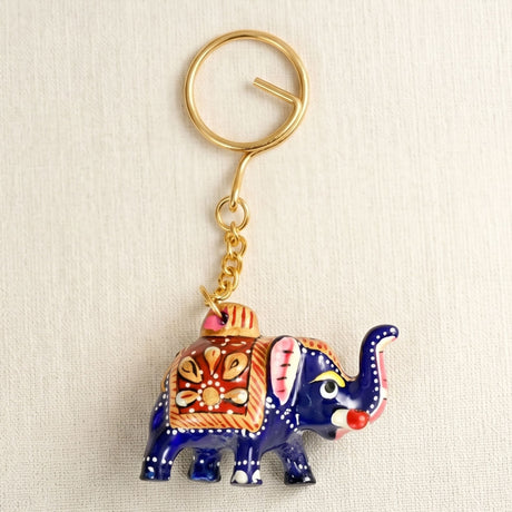 Handmade ceramic blue elephant keychain with intricate orange white patterns and gold hardware for good luck charm
