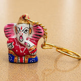 Handmade ceramic ganesha amulet keychain with vibrant pink red and blue accents and gold chain for housewarming gifts