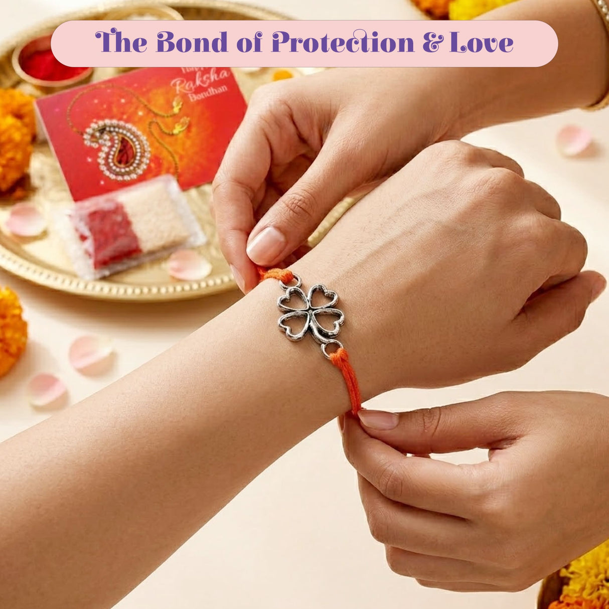 A silver four-leaf clover charm bracelet with an orange cord for traditional Raksha Bandhan protection and good luck