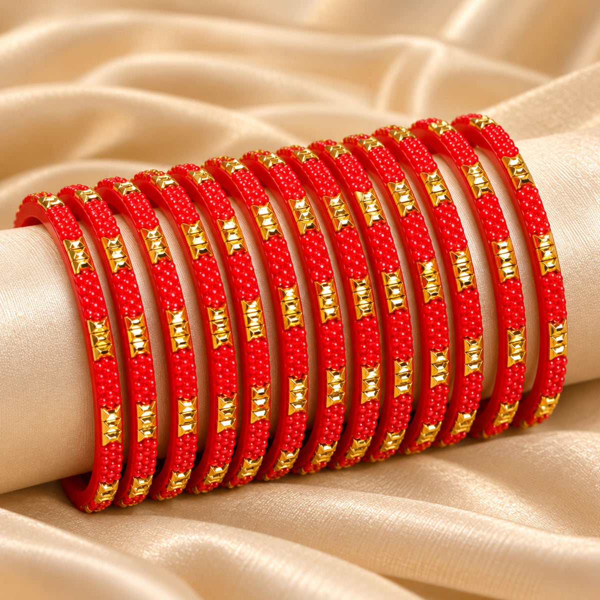A set of vibrant red handcrafted glass bangles with gold-tone rectangular accents elegantly stacked on a wrist