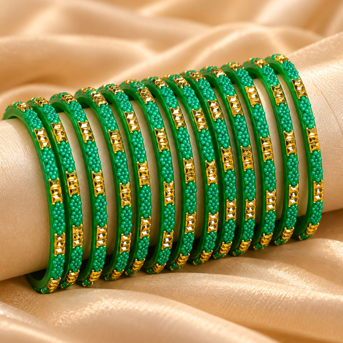 A set of vibrant green glass bangles with gold-tone rectangular embellishments and delicate beadwork for bridal wear