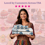 Woman in maroon gold dress holds 3 folded Indian elephant print cotton sheets