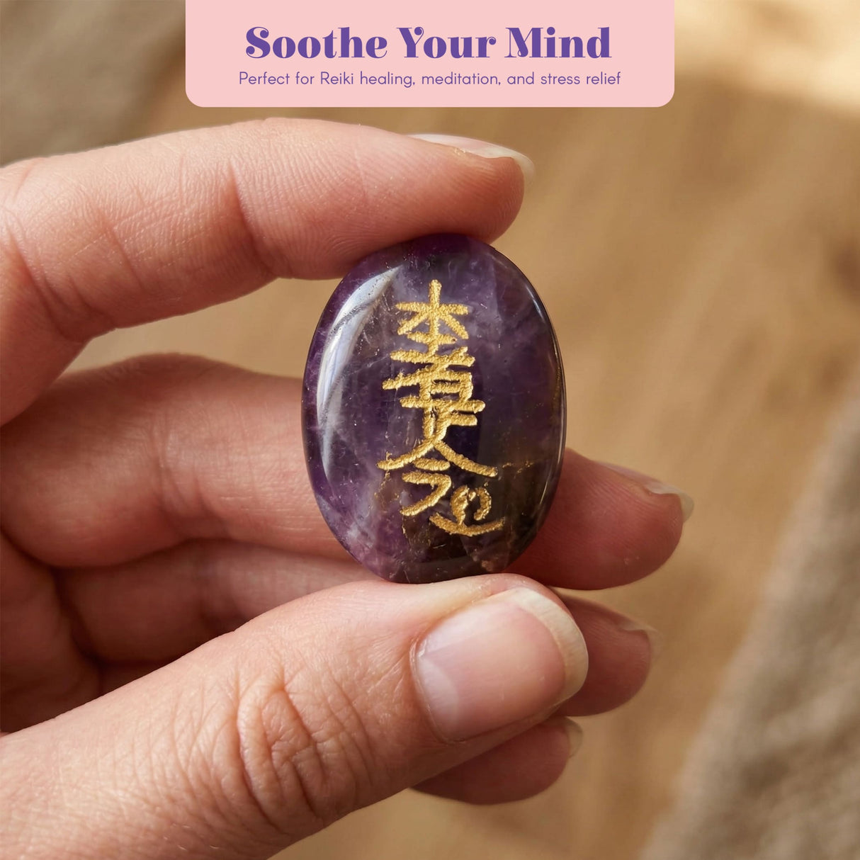 A smooth oval-shaped purple amethyst crystal reiki stone with golden chinese characters engraved for chakra balancing