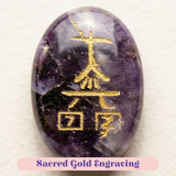 A polished oval amethyst crystal reiki stone with sacred gold engraved chinese characters for chakra balancing