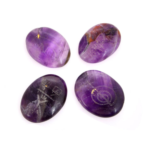 Four polished amethyst stones with engraved symbols for chakra balancing and meditation
